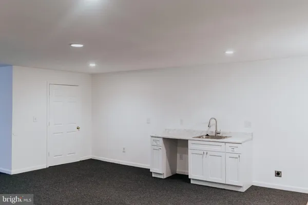 a room with white cabinets and sink