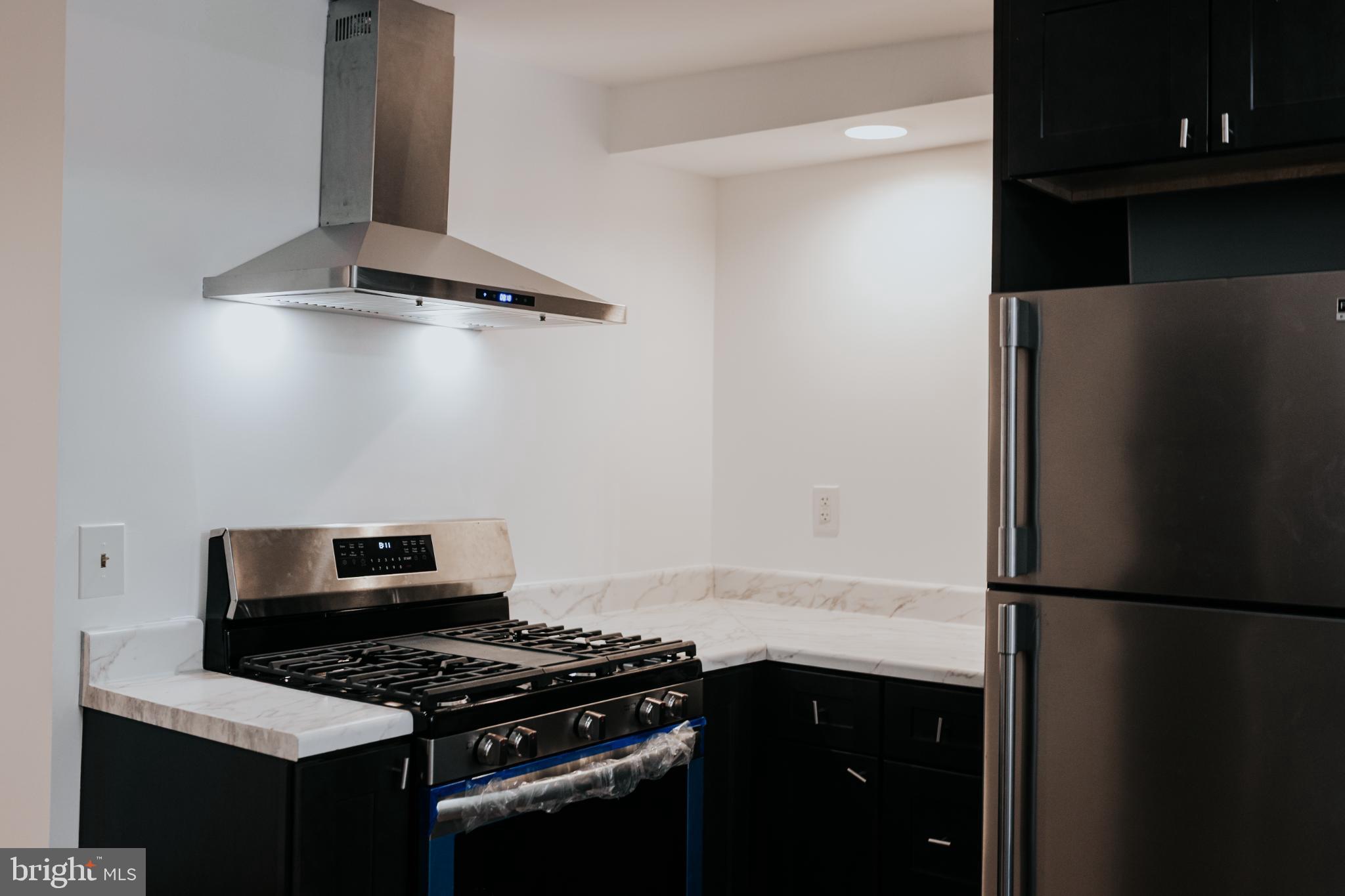 2511 Madison Avenue, Unit 1 Baltimore, MD 21217 - Photo 6 of 23 a kitchen with a refrigerator and a stove