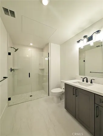 a bathroom with a double vanity sink toilet and shower