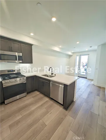 a large kitchen with a large counter top stainless steel appliances and cabinets