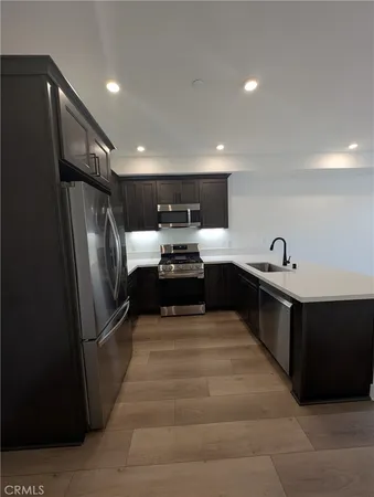 a kitchen with stainless steel appliances granite countertop a refrigerator and a sink