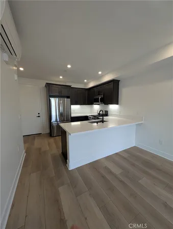 a large kitchen with stainless steel appliances a large counter top