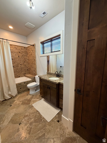 4536 North 475 East Provo, UT 84604 - Photo 33 of 65 Bathroom featuring large format floor tiles with dark accent squares, a dark wood vanity with a granite countertop and undermount sink, a tiled bathtub surround, and a dark wood door