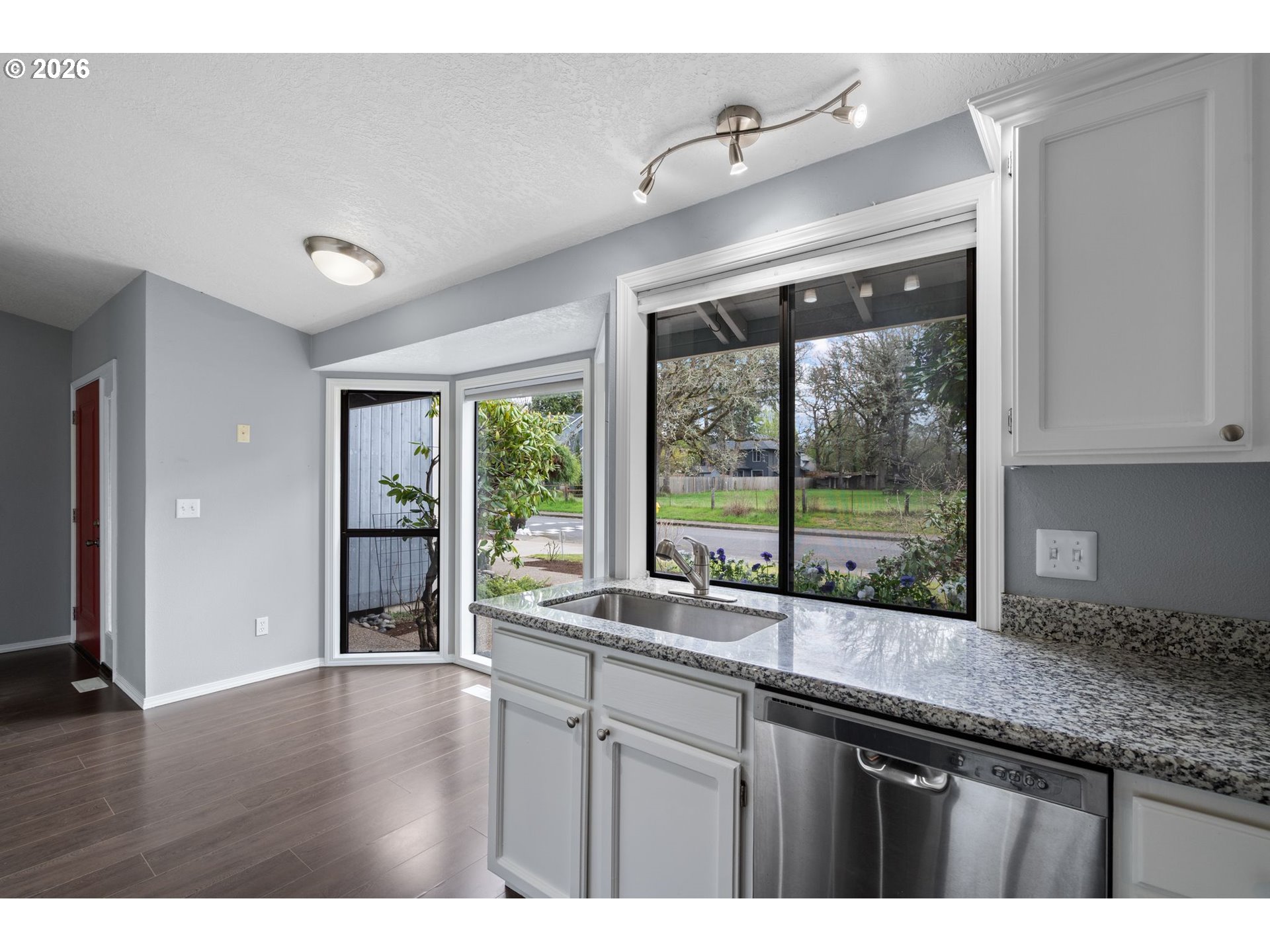 895 Southwest 166th Avenue Beaverton, OR 97006 - Photo 6 of 36 a kitchen with granite countertop a sink and a large window