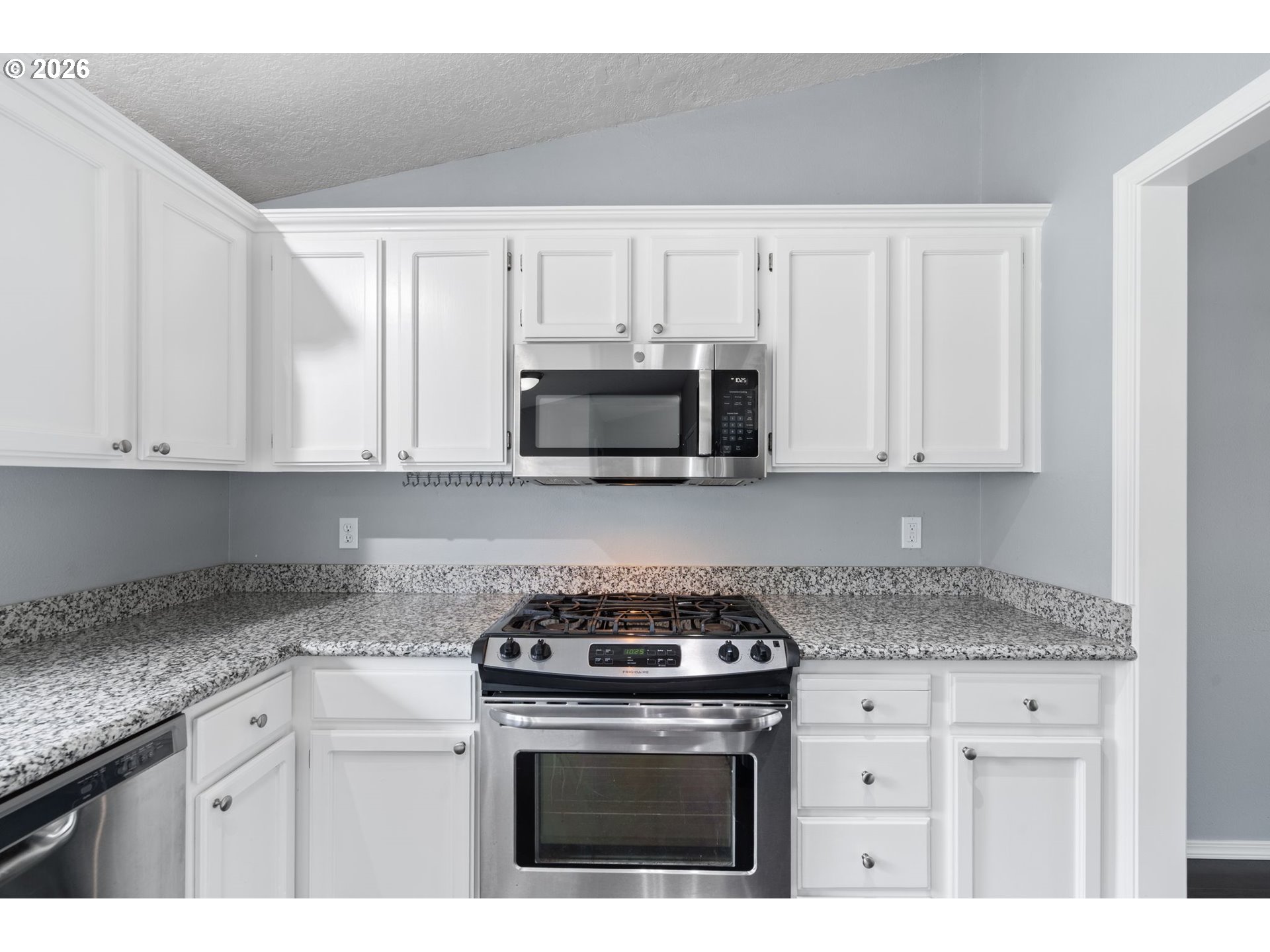 895 Southwest 166th Avenue Beaverton, OR 97006 - Photo 10 of 36 a kitchen with granite countertop white cabinets and stainless steel appliances