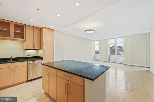 a kitchen with granite countertop a sink and cabinets with wooden floor