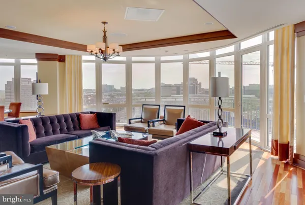 a living room with furniture pool table wooden floor and a large window