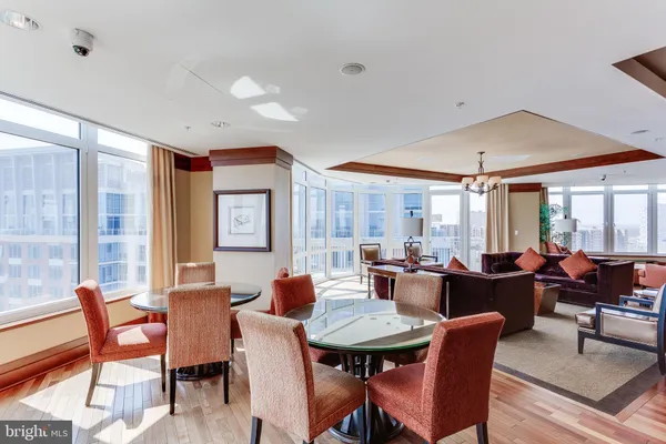 a dining hall with stainless steel appliances granite countertop a dining table and chairs with wooden floor