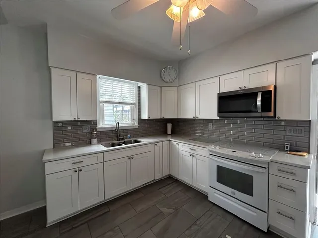 a kitchen with a sink stove and microwave
