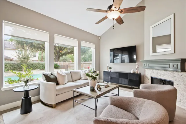a living room with furniture a fireplace and a large window