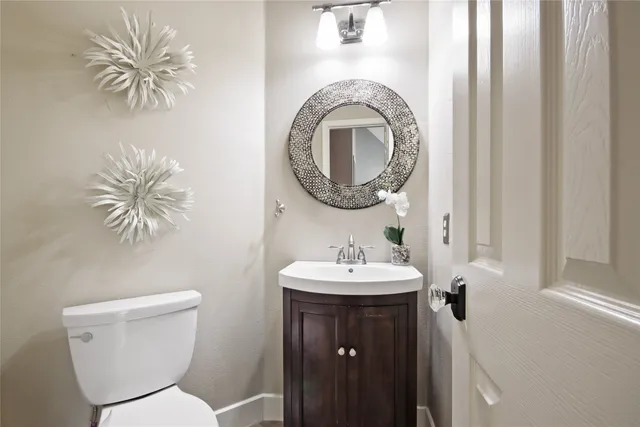a bathroom with a toilet a sink and mirror