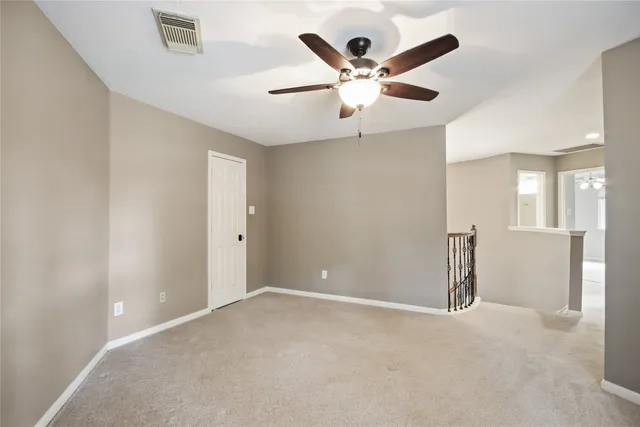 en empty room with ceiling fan and window