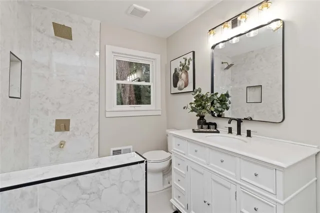 a bathroom with a sink vanity granite and a mirror