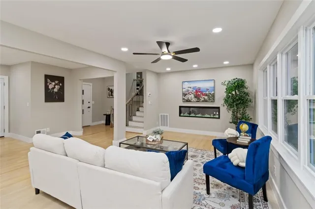 a living room with furniture and a ceiling fan