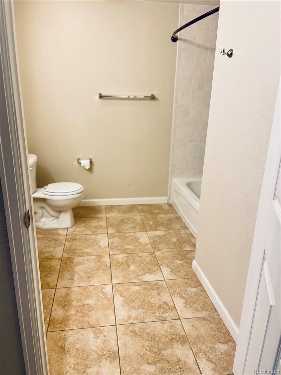 5800 Tower Road, Unit 102 Denver, CO 80249 - Photo 12 of 14 a bathroom with a toilet and a shower