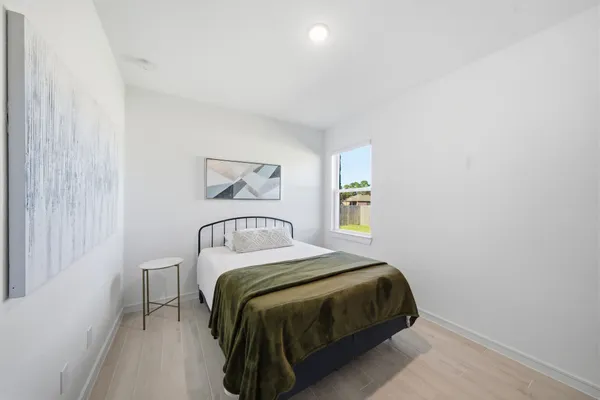 a bedroom with a bed and a window