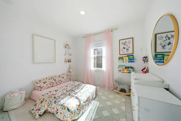 a room with furniture a rug toys and a window