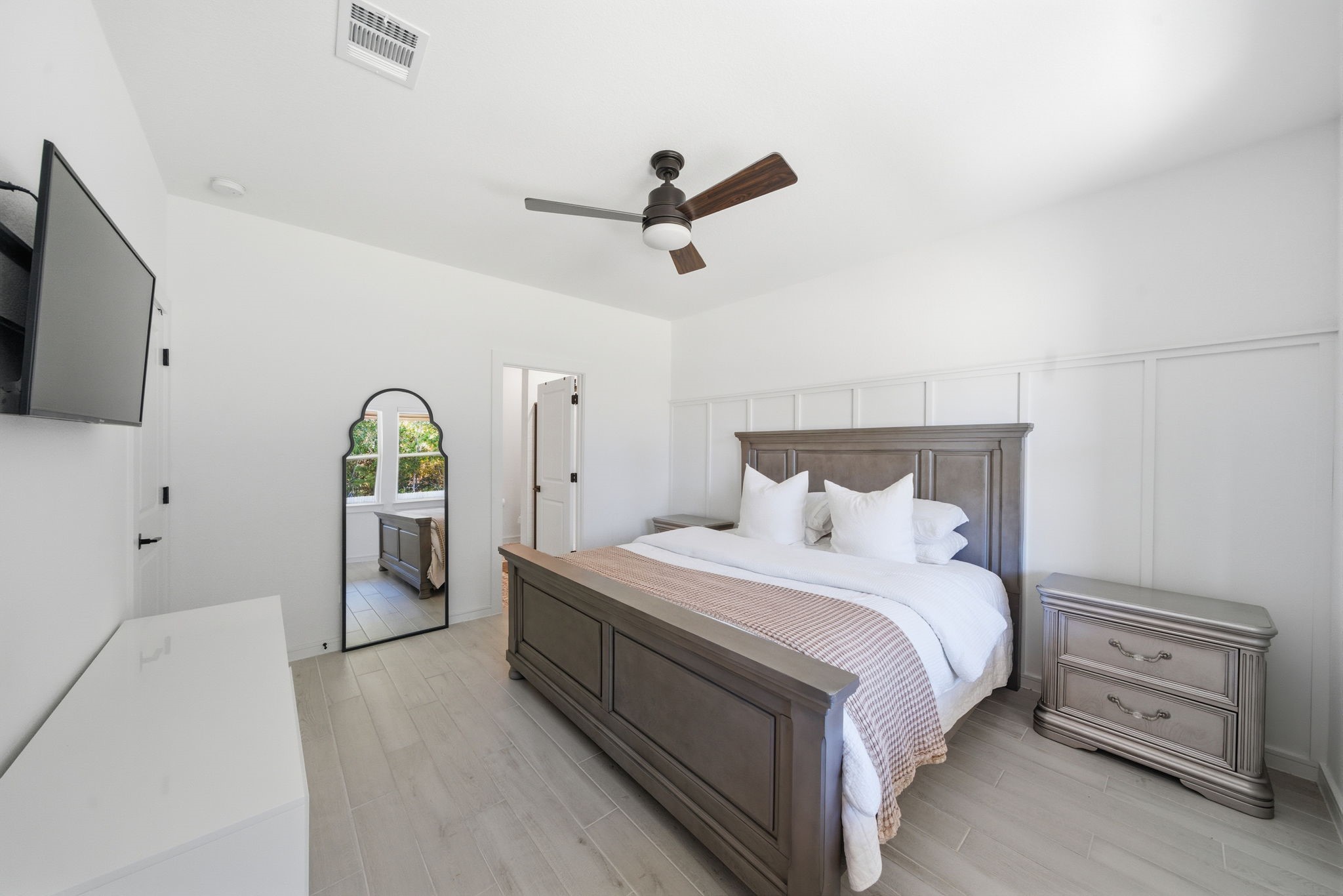 302 Alder Loop Anahuac, TX 77514 - Photo 19 of 34 This bedroom features a modern design with and a ceiling fan. Natural light streams in making this primary bedroom bright and inviting, perfect for relaxation.