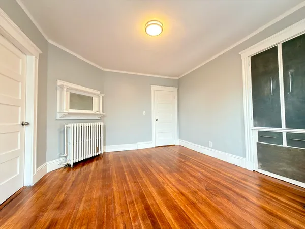a view of empty room with wooden floor and fireplace