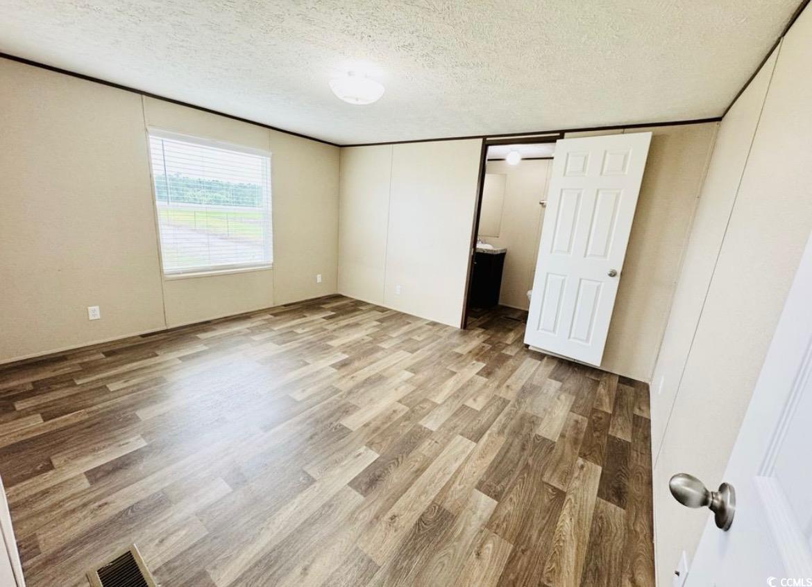 2433 Old Corner Court Marion, SC 29571 - Photo 13 of 18 Unfurnished bedroom featuring a textured ceiling and wood finished floors