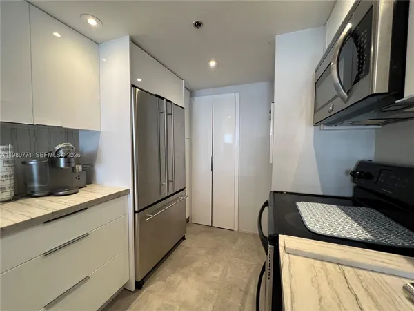 a kitchen with a refrigerator sink and cabinets