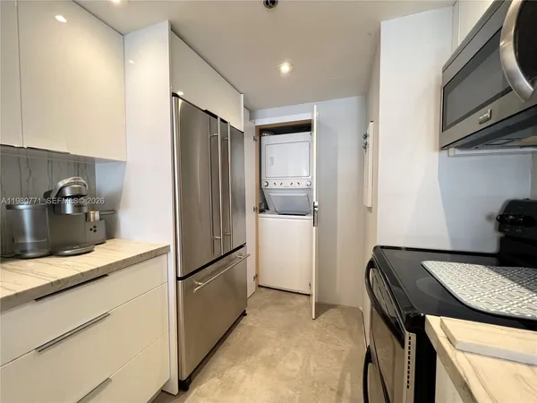 a kitchen with stainless steel appliances granite countertop a refrigerator and a sink