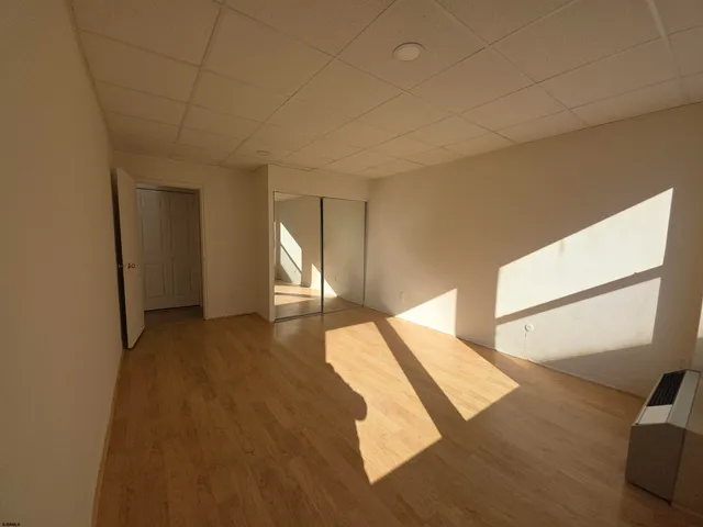 a view of a bedroom with wooden floor