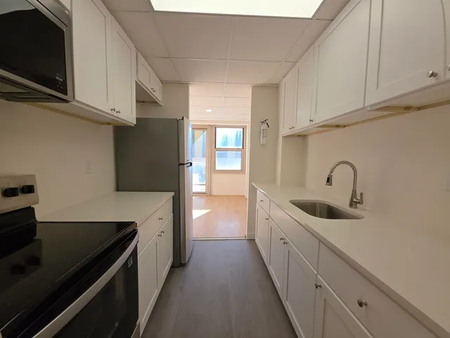 a kitchen with stainless steel appliances a sink stove top oven and cabinets
