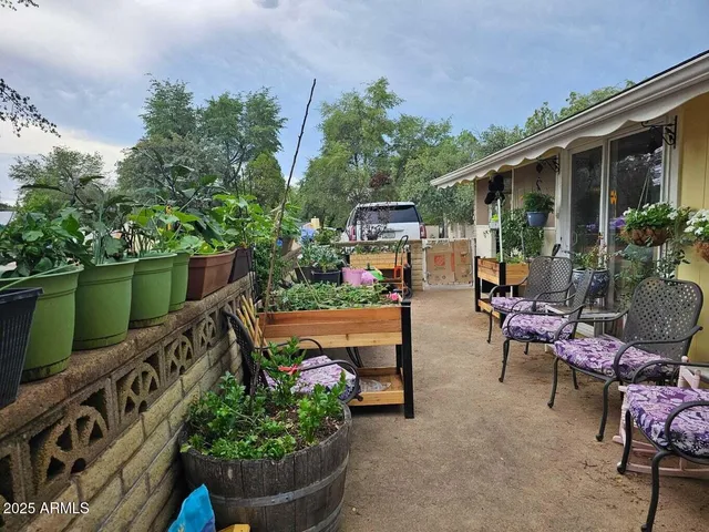 a view of a patio with couches and table and chairs and potted plants