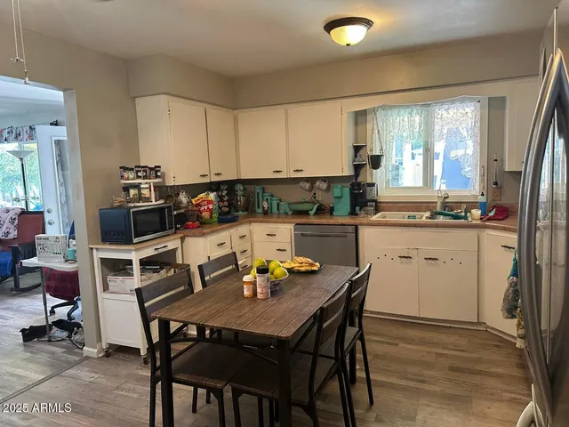 a kitchen with a dining table chairs and white appliances