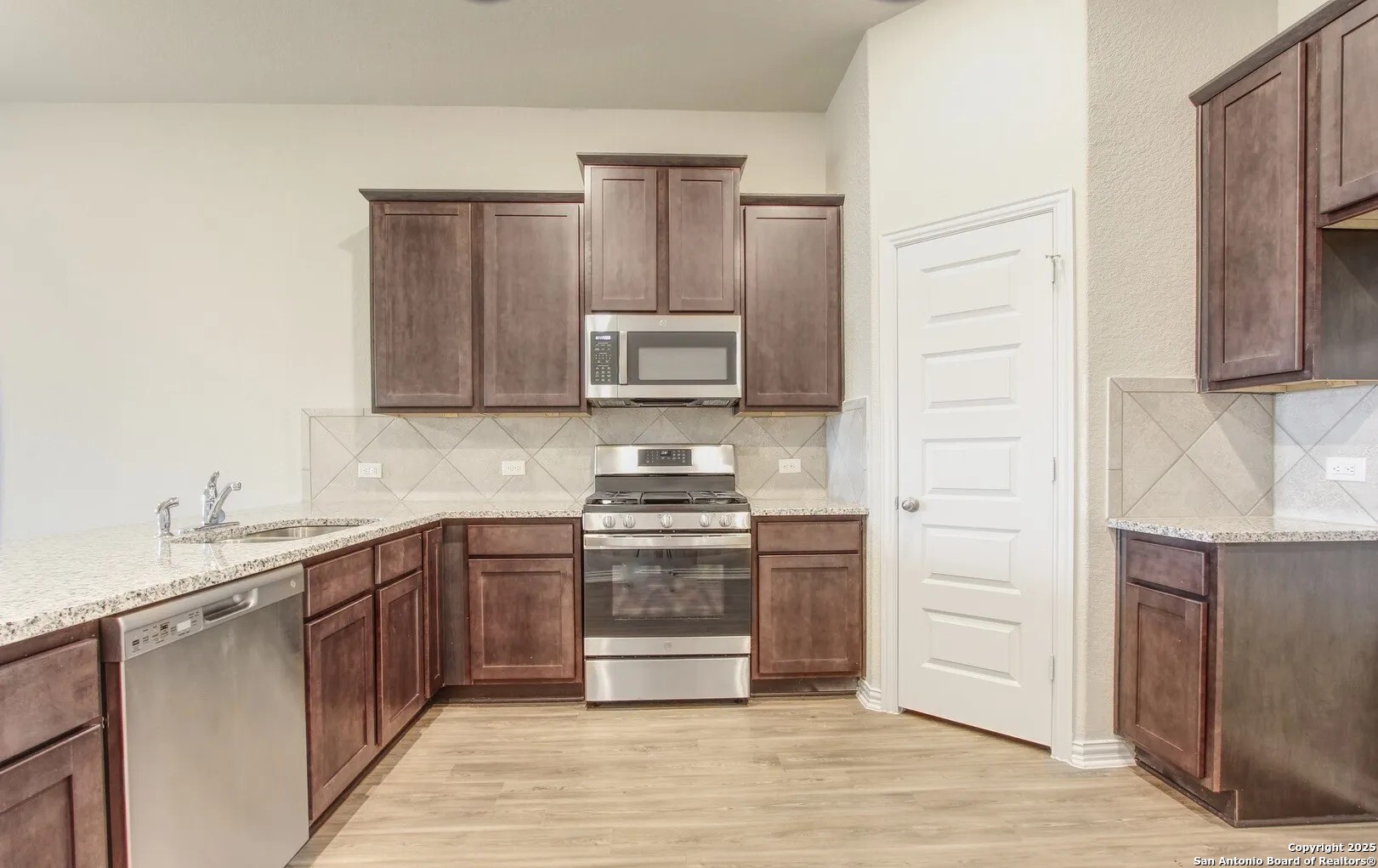 5423 Devils Gate Converse, TX 78109 - Photo 11 of 17 a kitchen with stainless steel appliances granite countertop a stove a sink and a microwave