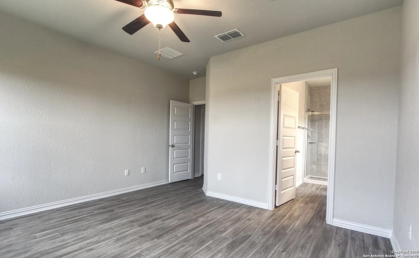 5423 Devils Gate Converse, TX 78109 - Photo 15 of 17 an empty room with wooden floor chandelier fan and windows