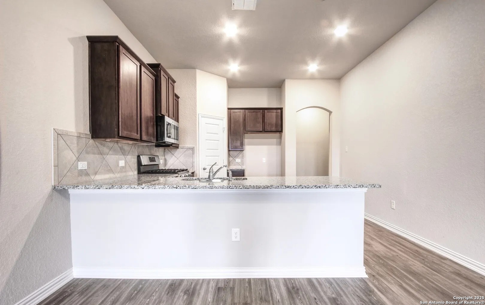 5423 Devils Gate Converse, TX 78109 - Photo 9 of 17 a view of a kitchen with kitchen island a sink wooden floor and glass door