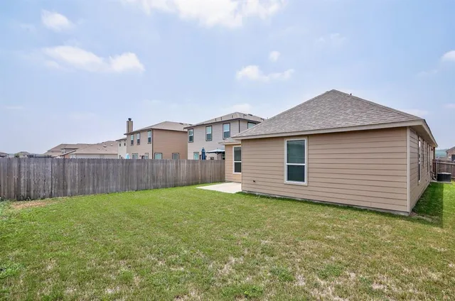 a view of a house with a yard and wooden fence