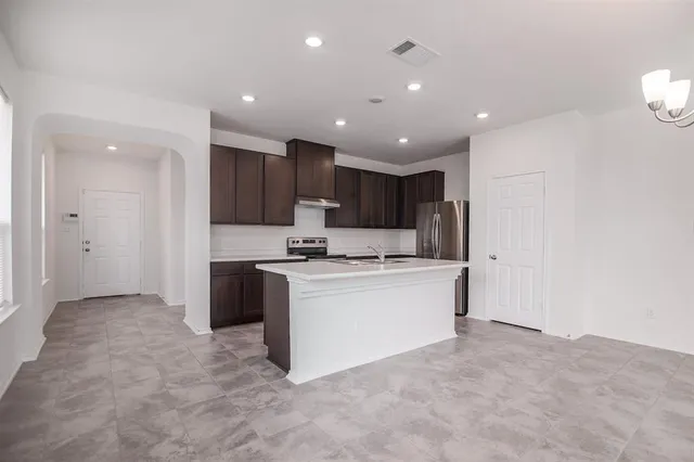 a kitchen with kitchen island a sink and a stove top oven