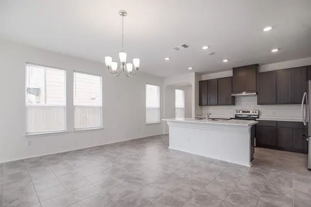 a kitchen with kitchen island a sink stainless steel appliances and window