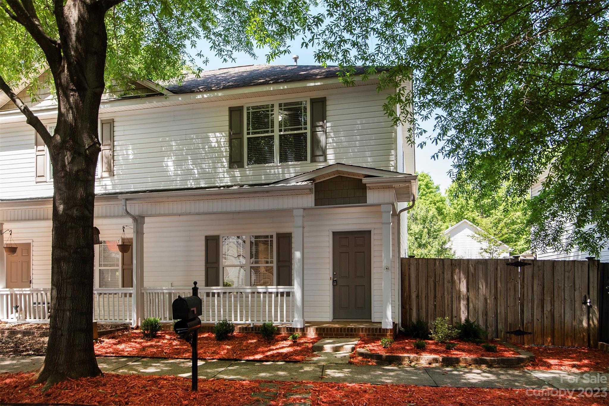 a front view of a house with a tree