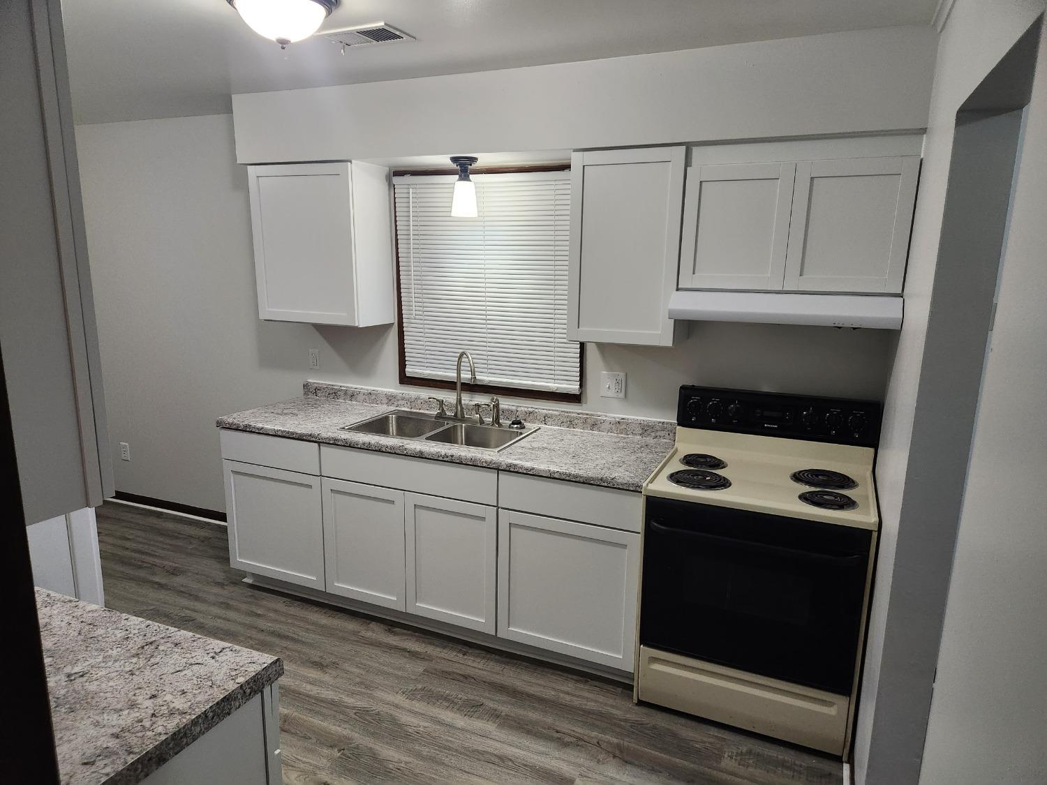 812 West Daumer Road, Unit C1 Kouts, IN 46347 - Photo 11 of 19 a kitchen with granite countertop white cabinets and white appliances