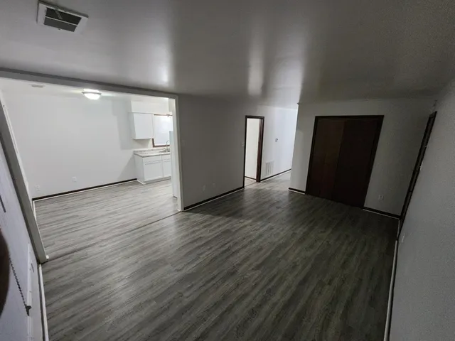 a view of a room with wooden floor and windows