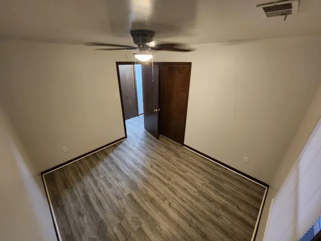 a view of a hallway with wooden floor and staircase