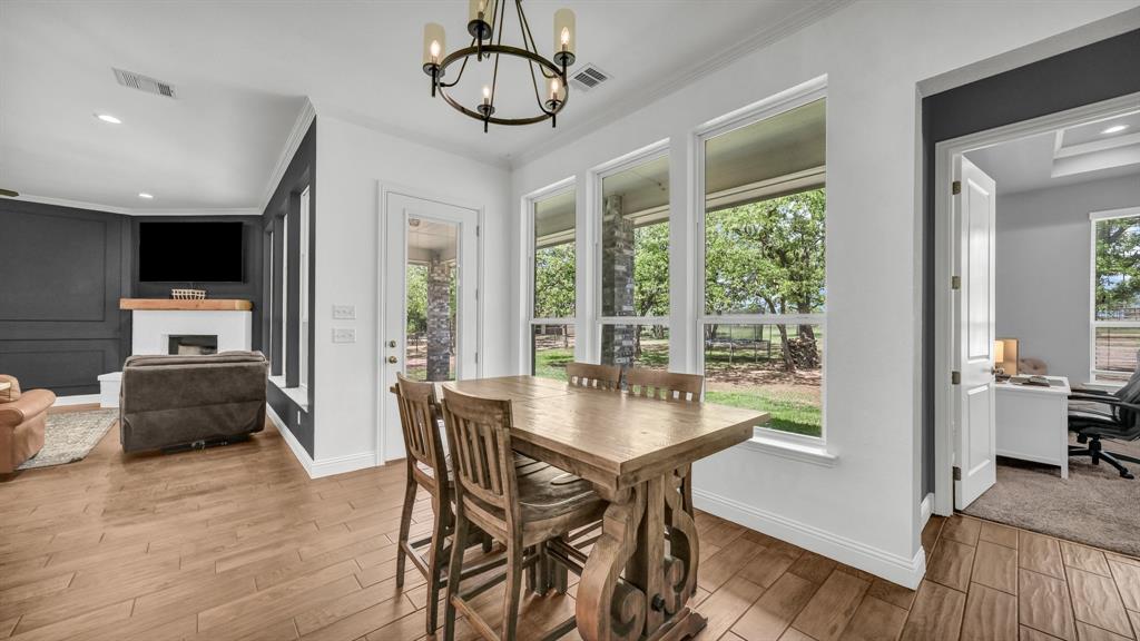 115 Post Oak Way Weatherford, TX 76087 - Photo 12 of 39 Dining area featuring a desk, a fireplace, wood finished floors, suspended lighting, and plenty of natural light