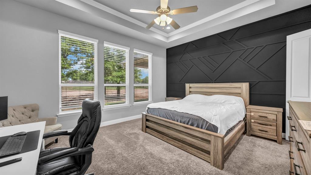 115 Post Oak Way Weatherford, TX 76087 - Photo 14 of 39 Carpeted bedroom with a desk, an accent wall, ceiling fan, a raised ceiling, and ornamental molding