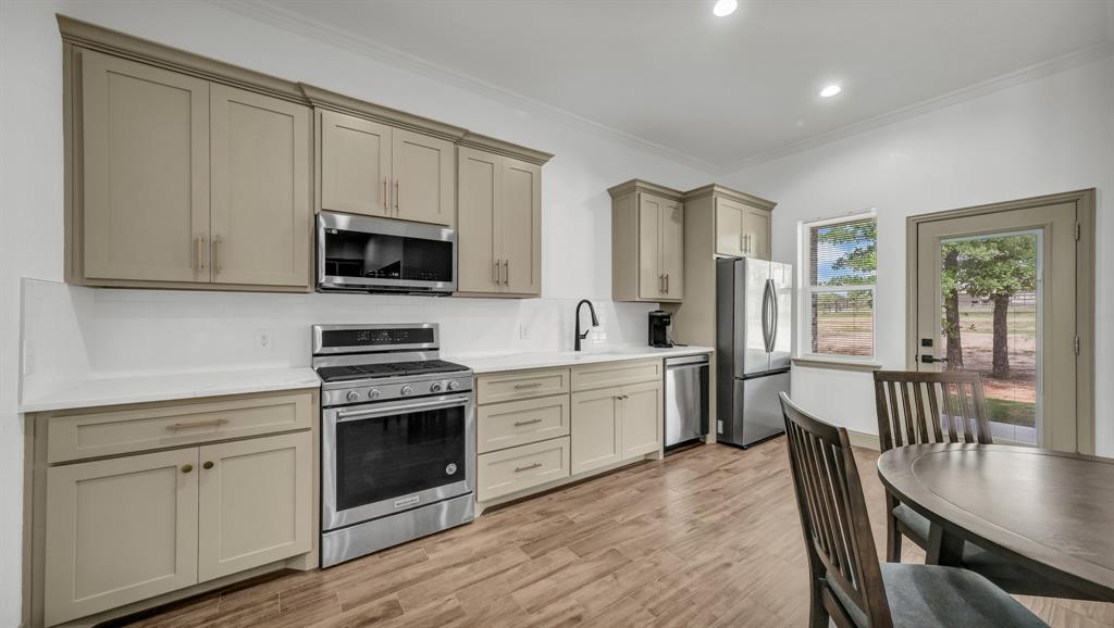 115 Post Oak Way Weatherford, TX 76087 - Photo 28 of 39 Kitchen with stainless steel appliances, ornamental molding, cream cabinets, light wood-type flooring, and recessed lighting