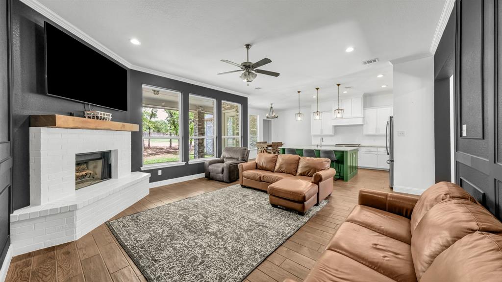 115 Post Oak Way Weatherford, TX 76087 - Photo 8 of 39 Living area with a brick fireplace, ornamental molding, light wood finished floors, ceiling fan, and recessed lighting