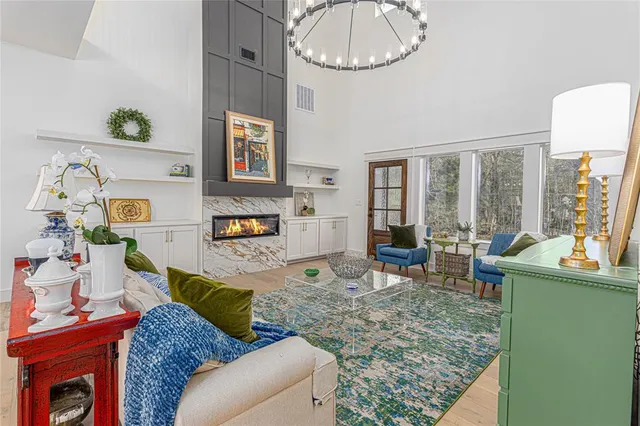 a living room with furniture chandelier and a large window