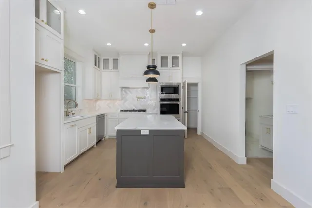 a kitchen with white cabinets and stainless steel appliances