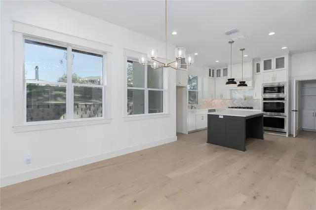 a large white kitchen with a large window