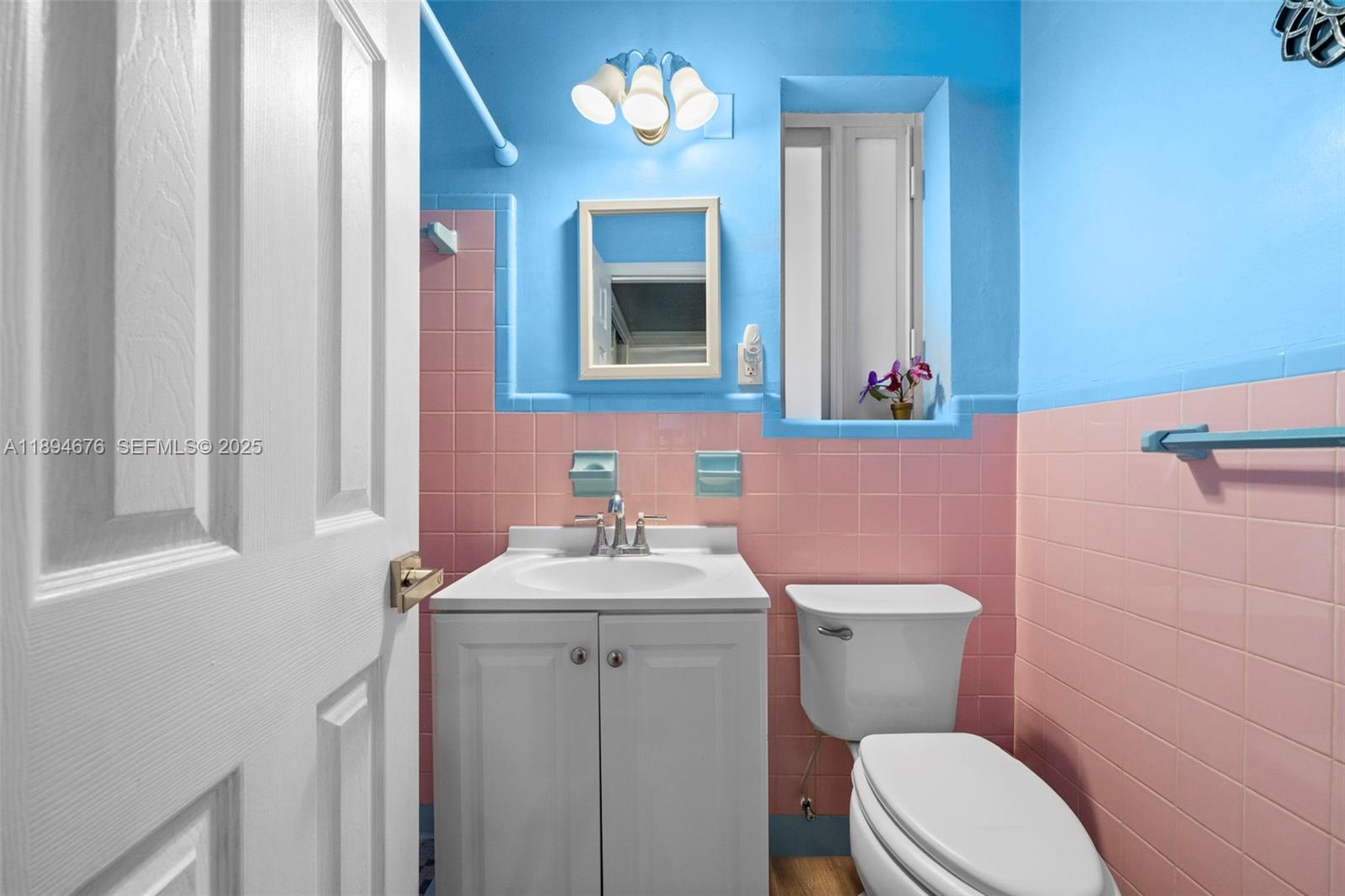 1271 Northwest 87th Street Miami, FL 33147 - Photo 23 of 29 a bathroom with a sink a toilet a mirror and shower curtain