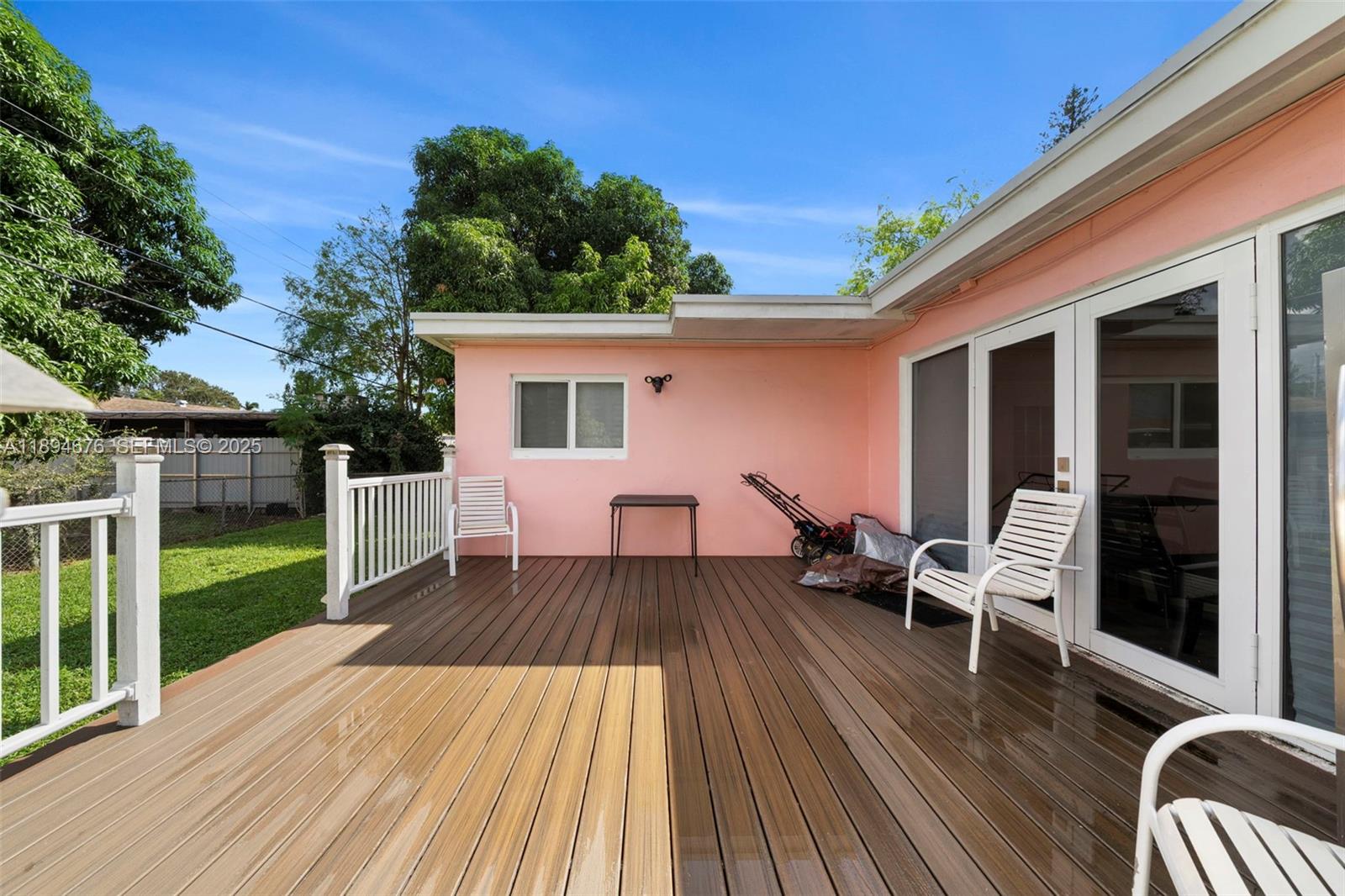 1271 Northwest 87th Street Miami, FL 33147 - Photo 26 of 29 a view of a patio with table and chairs with wooden floor and fence