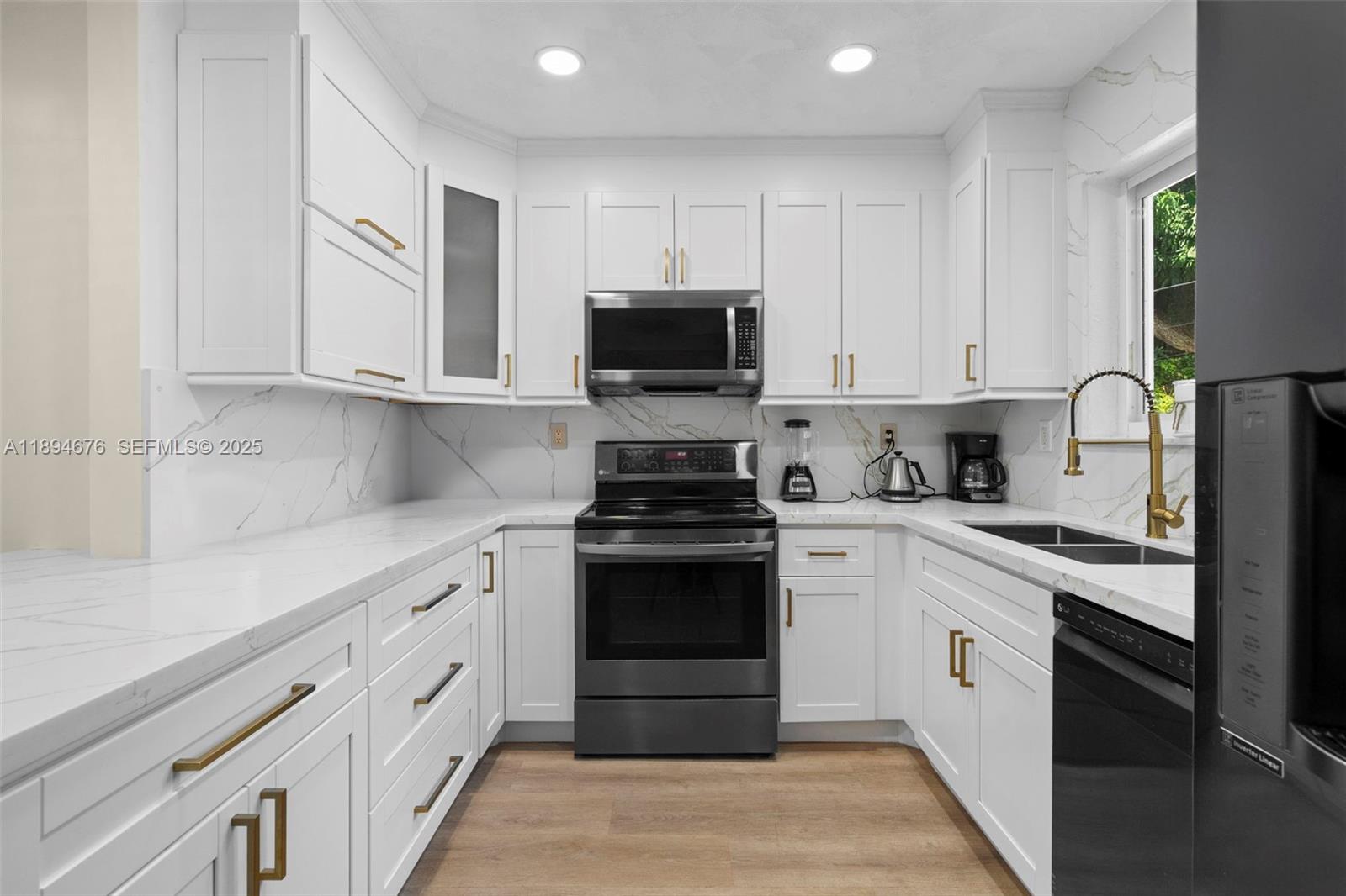 1271 Northwest 87th Street Miami, FL 33147 - Photo 8 of 29 a kitchen with granite countertop white cabinets and stainless steel appliances